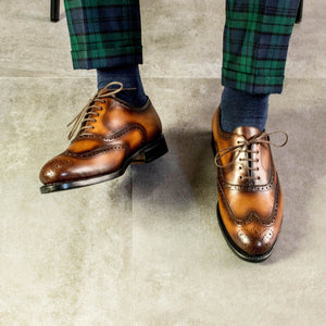 Lookbook Man wearing green and blue  check window pane trousers, blue socks,  and Cognac Calf Leather Goodyear Welted with leather and rubber sole Wingtip Oxford Brogue Dress Shoes